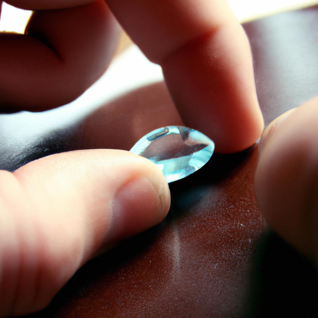 Person examining aquamarine gemstone closely
